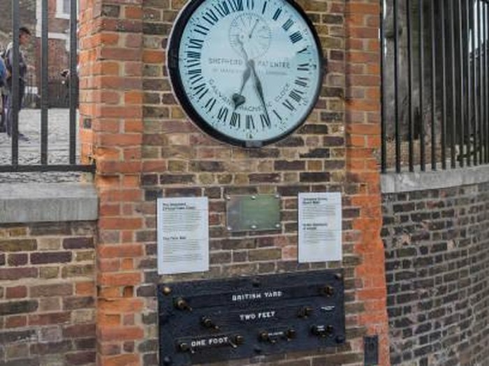 London, United Kingdom - Sep. 18, 2015: Shepherd Gate Clock and Public Standards of Lenght are mounted on the wall outside the gate of the Royal Greenwich Observatory building in Greenwich, London
