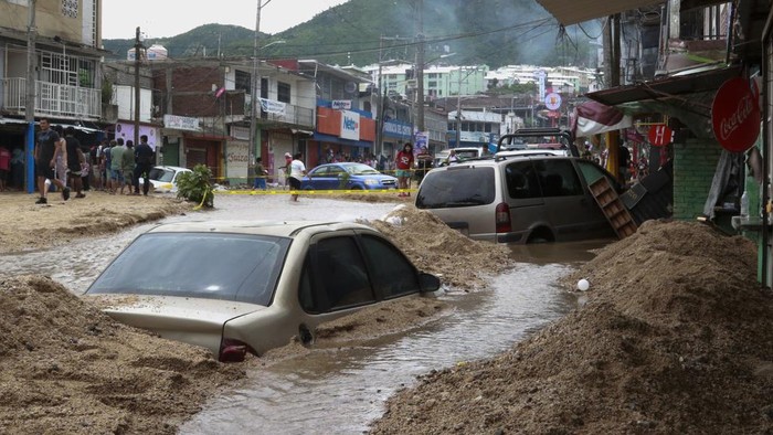 Vehicles are partially submerged on a flooded street in the aftermath of Hurricane John in Acapulco, Mexico, Saturday, Sept. 28, 2024. (AP Photo/Alejandrino Gonzalez)