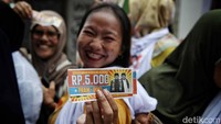 Warga tampak antusias menerima kupon sembako murah dari Pramono. 