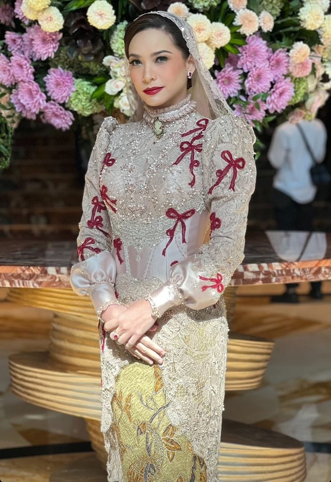 Rachel Maryam tampil glamor dengan kebaya couture rancangan Maison Baaz. Kebaya bernuansa beige-emas tampil atraktif dengan aksen pita, payet serta manik-manik. Kebaya dipadukan kain batik motif floral. Foto: Instagram/@maisonbaazcouture