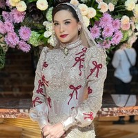 Rachel Maryam tampil glamor dengan kebaya couture rancangan Maison Baaz. Kebaya bernuansa beige-emas tampil atraktif dengan aksen pita, payet serta manik-manik. Kebaya dipadukan kain batik motif floral. Foto: Instagram/@maisonbaazcouture
