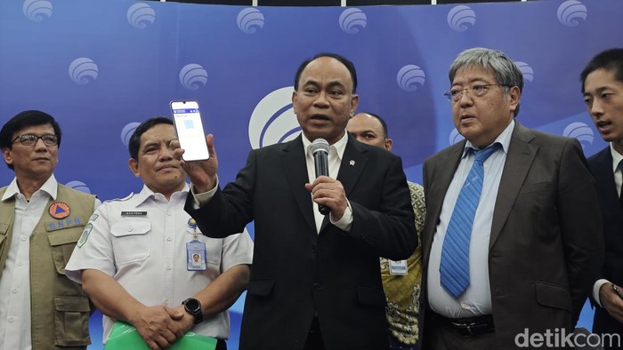 Menkominfo Budi Arie Setiadi menunjukan bentuk informasi kebencanaan di ponsel.