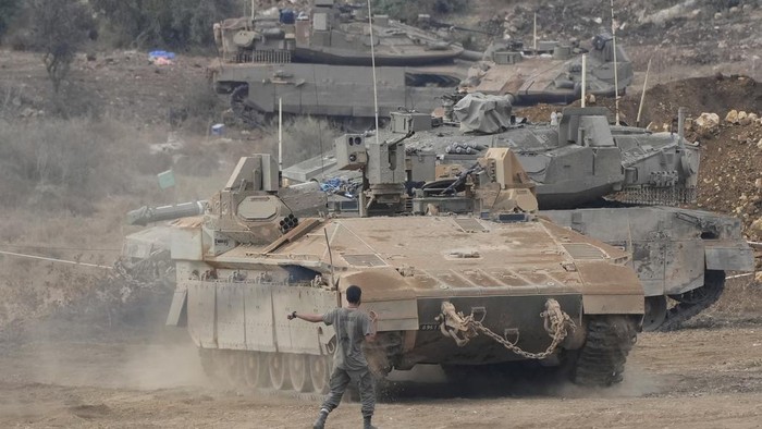 Israeli armored personnel carriers (APC) and tanks maneuver in a staging area in northern Israel near the Israel-Lebanon border, Tuesday, Oct. 1, 2024. (AP Photo/Baz Ratner)
