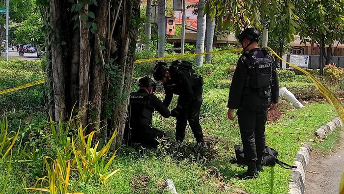 Tim Gegana penjinak bom mengevakuasi granat nanas yang ditemukan di taman seberang Gereja Kristus Raja.
