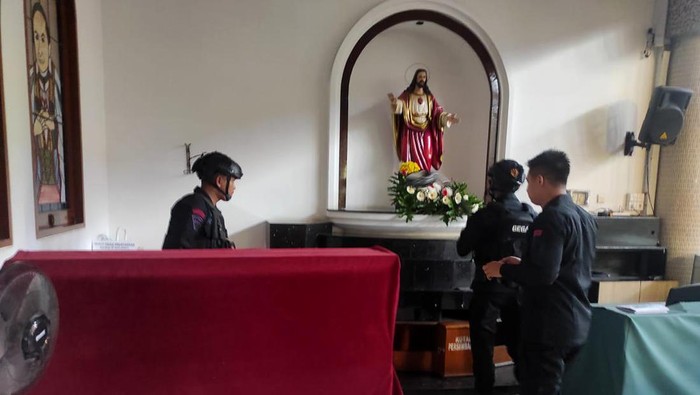 Tim Gegana penjinak bom mengevakuasi granat nanas yang ditemukan di taman seberang Gereja Kristus Raja.