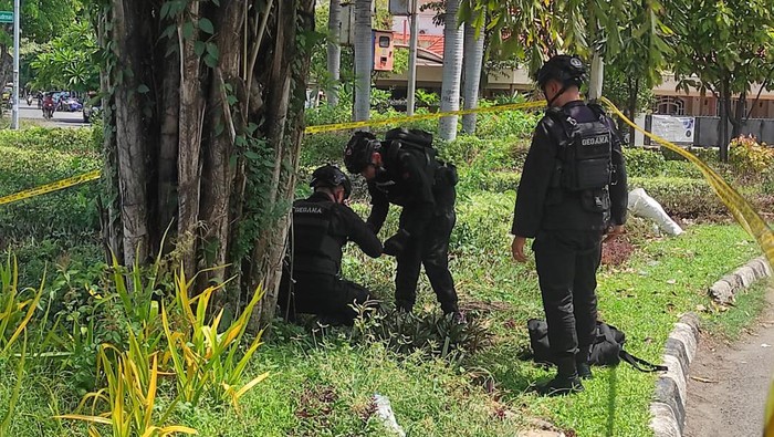 Tim Gegana penjinak bom mengevakuasi granat nanas yang ditemukan di taman seberang Gereja Kristus Raja.