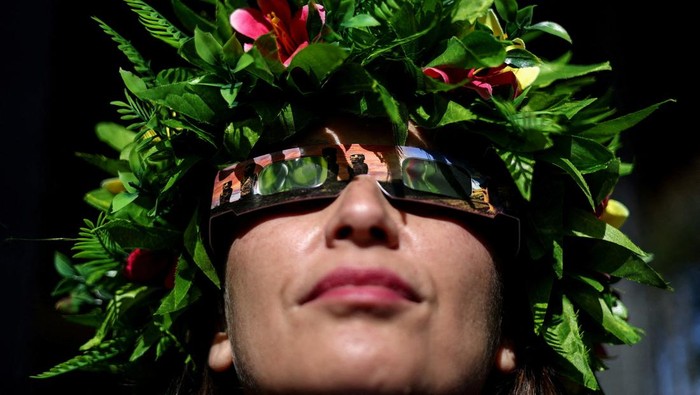 A visitor wears special protective glasses to observe the upcoming solar eclipse at Hanga Piko archaeological monument area at Rapa Nui national park managed by the Mau Henua native community at Easter Island, Chile October 1, 2024. REUTERS/Ivan Alvarado