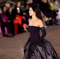 Ia melengkapi gayanya dengan sarung tangan opera. Riasannya natural, dengan rambut yang tergerai bebas. (Foto: River Callaway/WWD via Getty Images)