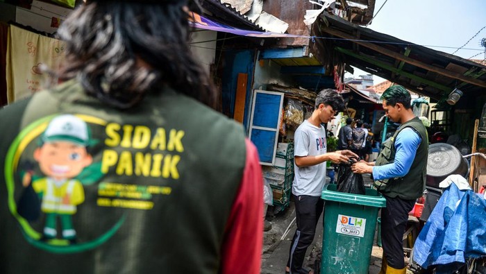 Petugas mengambil sampah organik milik warga di Lio Genteng, Nyengseret, Bandung, Jawa Barat, Rabu (2/10/2024). Kelurahan Nyengseret Kecamatan Astanaanyar melakukan inovasi layanan Sidak Panik (Simpen, candak, jemput sampah organik) yang merupakan layanan jemput bola sampah organik bagi masyarakat di permukiman padat yang tidak memiliki lahan untuk menyimpan sampah guna mengurangi produksi sampah organik di Kota Bandung. ANTARA FOTO/Raisan Al Farisi/wpa.