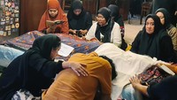Keluarga membaca ayat suci Alquran di samping jenazah Marissa Haque. Kesedihan juga terlihat di wajah keluarga yang ditinggalkan.