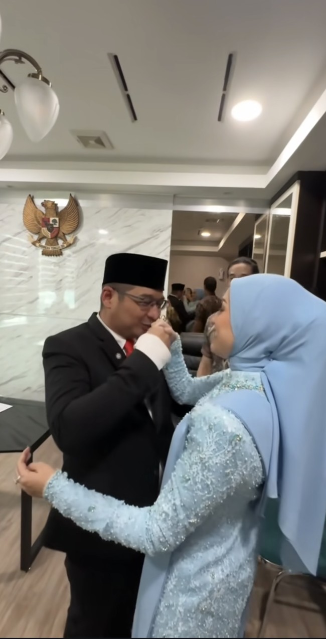 Pasha pun tampak membalas dengan mencium tangan istrinya. Adel yang mengenakan kebaya biru berhijab itu pun langsung tersenyum. Foto: Instagram/@adeliapasha