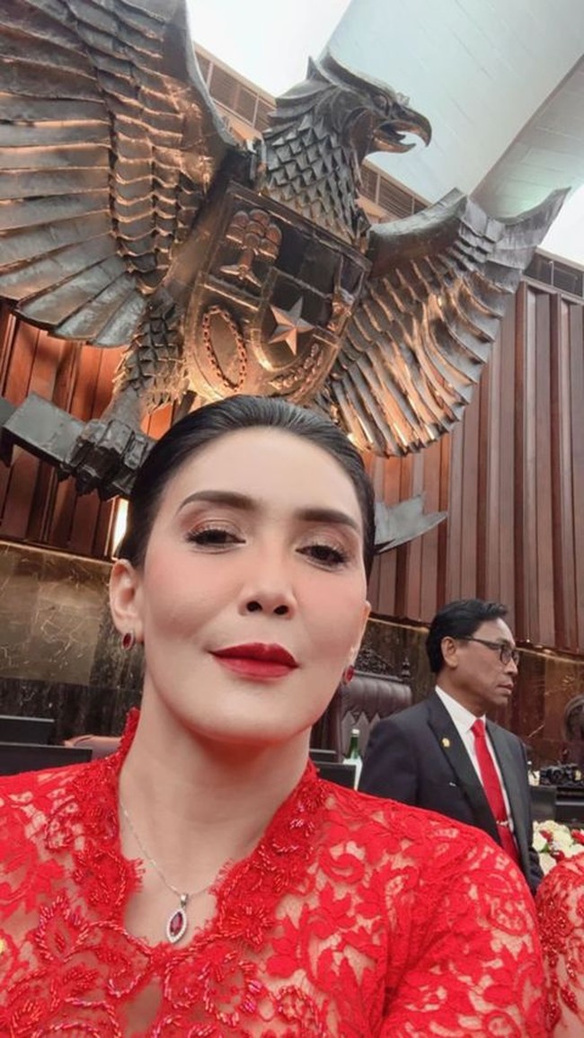 Rieke Dyah Pitaloka memilih kebaya dengan warna sesuai warna partainya, PDI Perjuangan. Kebaya lace dengan kerah model V dipercantik kalung berbatu merah delima. Politikus yang pernah jadi aktris ini merias wajahnya dengan pulasan lipstik merah. Foto: Instagram @riekediahp