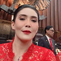Rieke Dyah Pitaloka memilih kebaya dengan warna sesuai warna partainya, PDI Perjuangan. Kebaya lace dengan kerah model V dipercantik kalung berbatu merah delima. Politikus yang pernah jadi aktris ini merias wajahnya dengan pulasan lipstik merah. Foto: Instagram @riekediahp