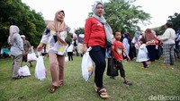 Warga meninggalkan lokasi usai mendapatkan paket sembako murah.