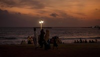 Di ibu kota Sri Lanka, senja di tepi laut menjadi momen yang menakjubkan. Warna keemasan matahari terbenam memantul di permukaan laut, menciptakan suasana damai yang sering dinikmati oleh penduduk lokal dan turis. AP Photo/Markus Schreiber 