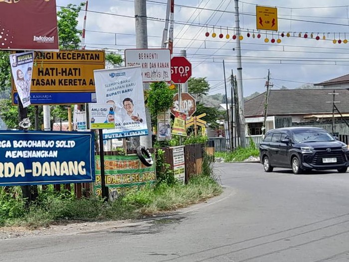 Alat peraga kampanye (APK)  yang terpasang di palang pintu kereta api di Prambanan, Sleman. Foto diunggah pada Kamis (3/10/2024).