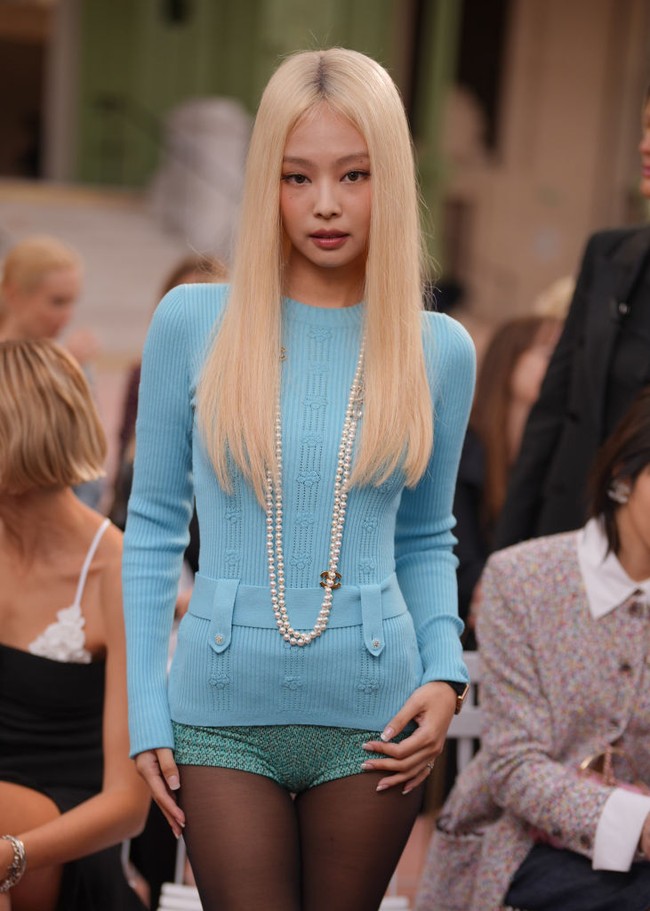 Saat menghadiri fashion show Chanel, Jennie memakai atasan panjang berwarna biru dengan celana super pendek serasi, stoking hitam, dan kalung mutiara. Foto: Getty Images