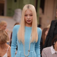 Saat menghadiri fashion show Chanel, Jennie memakai atasan panjang berwarna biru dengan celana super pendek serasi, stoking hitam, dan kalung mutiara. Foto: Getty Images