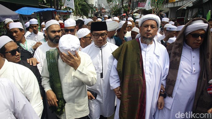 Momen Ridwan Kamil Digandeng Habib Ali Kwitang Ridwan Kamil bertemu ulama dan tokoh agama di kawasan Kwitang, Senen, Jakarta Pusat. Ia menghadiri acara Maulid Akhir Kamis ke-104, di Jl Kramat II, Jakarta Pusat.