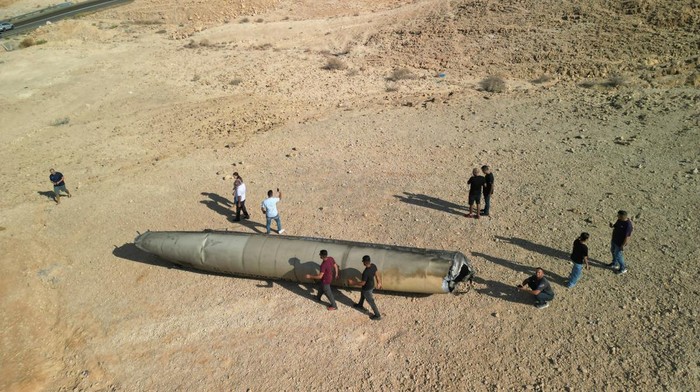 Penampakan Puing Rudal Balistik Iran Jadi Tontonan Warga Israel People walk around apparent remains of a ballistic missile lying in the desert, following an attack by Iran on Israel, near the southern city of Arad, Israel October 2, 2024. REUTERS/Amir Cohen