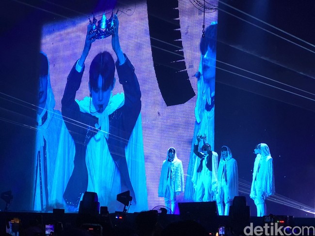 Konser TXT dibuka pukul 19.00 WIB. Kelima personel tampil memakai baju putih panjang di atas panggung. Salah satu personelnya, Yeonjun membuka tudung dan memakaikan mahkota di atas kepalanya. Foto: dok. R Chairini Putong/Wolipop