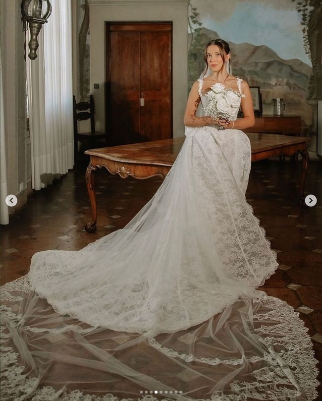 Pada momen upacara pernikahannya di Italia, Millie Bobby Brown tampil cantik mengenakan gaun pengantin putih. Gaun yang hadir dengan korset lace itu karya desainer couture, Galia Lahav. Foto: Dok. divinedayphotography, camillaboniekevents