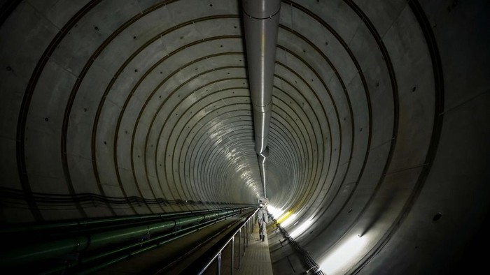 Shun Otomo, a member of the Tokyo Metropolitan Government Bureau of Construction, directs a visit inside the Ring Road No.7 Underground Wide Area Regulating Reservoir, which is under construction, near Nogata station in Tokyo, Japan, July 16, 2024. The system kicked in four times in June, more than all of last year, capturing water before pumping it safely into the Edogawa River and out to sea. 