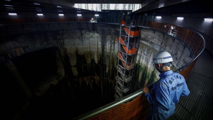 Shun Otomo, a member of the Tokyo Metropolitan Government Bureau of Construction, directs a visit inside the Ring Road No.7 Underground Wide Area Regulating Reservoir, which is under construction, near Nogata station in Tokyo, Japan, July 16, 2024. The system kicked in four times in June, more than all of last year, capturing water before pumping it safely into the Edogawa River and out to sea. 