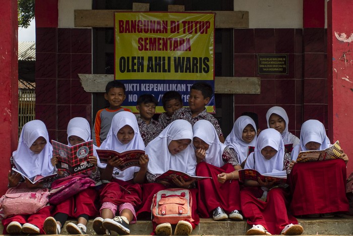 Siswa membaca buku di depan ruang kelas yang disegel di SDN Senangsari, Kecamatan Pagelaran, Pandeglang, Banten, Kamis (3/10/2024). Menurut pihak sekolah ruang kelas baru (RKB) yang diperuntukkan bagi siswa kelas enam tersebut telah disegel pihak yang mengaku ahli waris, sehingga kegiatan belajar mengajar terpaksa dilakukan di teras kelas atau dipindahkan ke ruang kelas lain yang tersedia. ANTARA FOTO/Angga Budhiyanto/Spt.