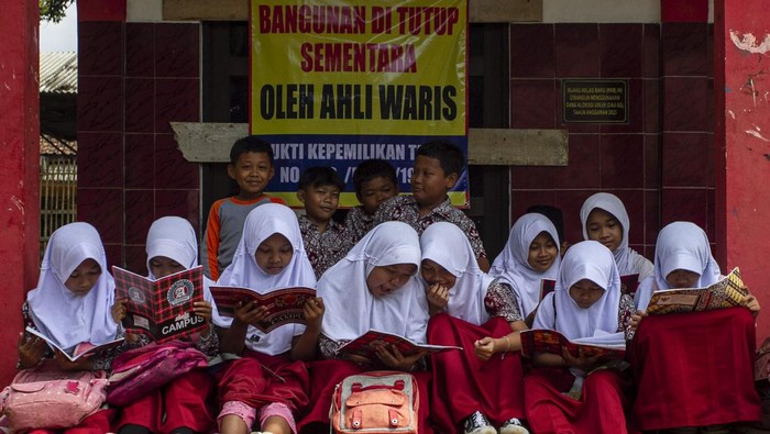 Ruang Kelas SDN Senangsari Banten Disegel 'Ahli Waris', Siswa Belajar di Teras Siswa membaca buku di depan ruang kelas yang disegel di SDN Senangsari, Kecamatan Pagelaran, Pandeglang, Banten, Kamis (3/10/2024). Menurut pihak sekolah ruang kelas baru (RKB) yang diperuntukkan bagi siswa kelas enam tersebut telah disegel pihak yang mengaku ahli waris, sehingga kegiatan belajar mengajar terpaksa dilakukan di teras kelas atau dipindahkan ke ruang kelas lain yang tersedia. ANTARA FOTO/Angga Budhiyanto/Spt.