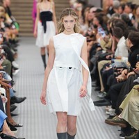 Sunday melenggang dengan gaun putih tanpa lengan beraksen pita di leher. Gaun minimalis dipadukan dengan kaus kaki hitam setinggi lutut dan sepatu peep-toe warna hitam. Foto: Gamma-Rapho via Getty Images/Victor VIRGILE