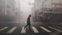 Seorang pria menyeberang jalan saat Topan Krathon mendekat, di Kaohsiung, Taiwan, Kamis (4/10/2024).  