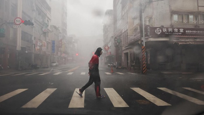 A person crosses the road as Typhoon Krathon approaches, in Kaohsiung, Taiwan October 3, 2024. REUTERS/Ann Wang TPX IMAGES OF THE DAY