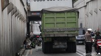 Truk sedang menunggu evakuasi. Petugas polisi mengatur lalu-lintas. 