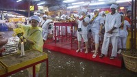 Sejumlah umat berpakaian putih menyalakan lilin dan memegang dupa selama festival Sembilan Dewa Kaisar.