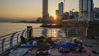 Keluarga-keluarga tidur di tepi pantai Beirut setelah melarikan diri dari serangan udara Israel di pinggiran selatan Beirut, Lebanon. Hizbullah mengatakan klaim Israel bahwa pasukannya masuk wilayah Lebanon adalah tidak benar. Kelompok milisi yang didukung Iran ini mengklaim tak ada konflik langsung antara para pejuangnya dan pasukan Israel, namun mereka mastikan bahwa mereka siap untuk menghadapi konfrontasi langsung. AP/Hassan Ammar