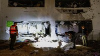 Anggota pasukan penyelamat Israel memeriksa lokasi tempat rudal yang ditembakkan dari Iran ke Israel menghantam gedung sekolah, di Israel tengah. Manuver ini dilakukan Teheran setelah Israel masih terus menyerang Palestina dan juga Lebanon untuk menumpas dua milisi pro Iran di masing-masing wilayah, Hamas dan Hizbullah. Israel bahkan telah berhasil membunuh pimpinan tertinggi Hizbullah, Sayyed Hassan Nasrallah dan juga Kepala Biro Politik Hamas, Ismail Haniyeh. REUTERS/Amir Cohen
