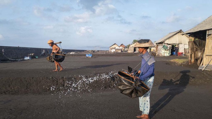 Foto Udara Produksi Garam di Klungkung Bali BALI, INDONESIA - SEPTEMBER 21: Farmers spread sea water on the black sand to produce salt using traditional treatment at Kusamba Beach in Klungkung, Bali, Indonesia, September 21, 2024. The salt farmers in this region face serious problems, ranging from erratic weather to shrinking production land areas due to coastal erosion as an impact of climate change. In a day, each group of farmers produce 10-15 kg of salt and selling it for 1 USD/kg for the local market. In 2022, the government built a sea wall, but sometimes it was not able to hold back the big waves that came and damaged their salt production land. (Photo by Agoes Rudianto/Anadolu via Getty Images)