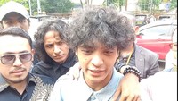 Vadel tersenyum tipis saat tiba di Polres Jakarta Selatan sekitar pukul 14.245 WIB. Foto: Ahsan/detikHOT