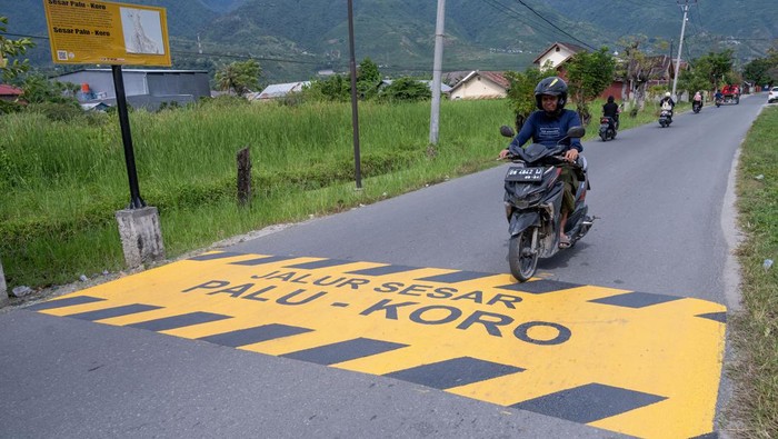Pengendara sepeda motor melintas di atas penanda jalur sesar Palu-Koro di Jalan Lasoso, Palu Barat, Kota Palu, Sulawesi Tengah, Jumat (4/10/2024). Dinas Pekerjaan Umum Kota Palu membuat dan memasang penanda di sejumlah ruas jalan yang dilewati salah satu sesar teraktif di Indonesia itu sebagai peringatan sekaligus edukasi dan mitigasi bagi masyarakat setempat untuk menigkatkan kewaspadaan di wilayah yang rawan bencana tersebut. ANTARA FOTO/Basri Marzuki/tom.