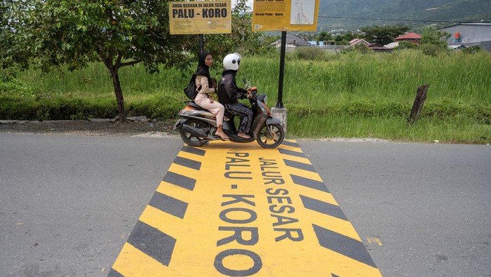 Pengendara sepeda motor melintas di atas penanda jalur sesar Palu-Koro di Jalan Lasoso, Palu Barat, Kota Palu, Sulawesi Tengah, Jumat (4/10/2024). Dinas Pekerjaan Umum Kota Palu membuat dan memasang penanda di sejumlah ruas jalan yang dilewati salah satu sesar teraktif di Indonesia itu sebagai peringatan sekaligus edukasi dan mitigasi bagi masyarakat setempat untuk menigkatkan kewaspadaan di wilayah yang rawan bencana tersebut. ANTARA FOTO/Basri Marzuki/tom.