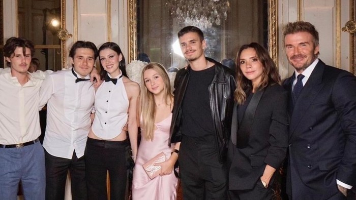 Keluarga Victoria Bekcham dan David Beckham foto bersama, Herper Beckham pakai gaun satin tipis.
