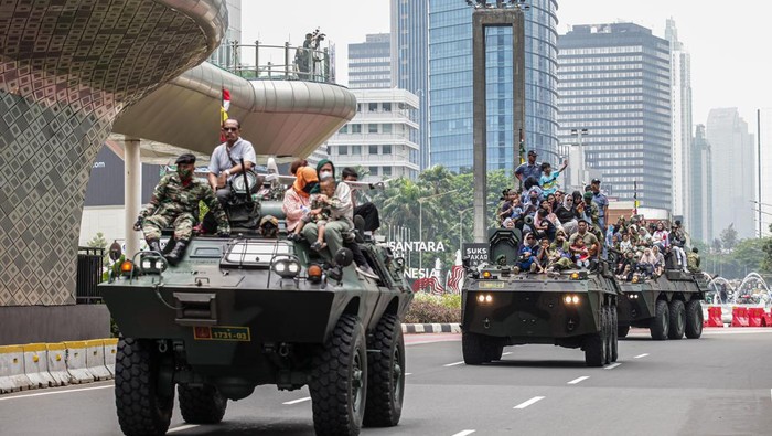 Pawai alutsista hari ini digelar dalam rangka memperingati HUT ke-79 TNI. Warga tampak berfoto di atas tank TNI saat pawai itu berlangsung.