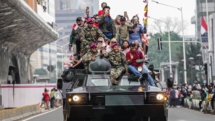 Potret Warga Ikut Naik Tank Saat Pawai Alutsista Melintas di Bundaran HI Pawai alutsista hari ini digelar dalam rangka memperingati HUT ke-79 TNI. Warga tampak berfoto di atas tank TNI saat pawai itu berlangsung.