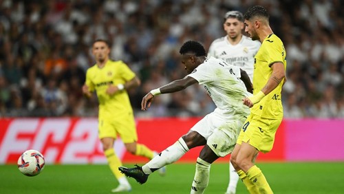 MADRID, SPAIN - OCTOBER 05: Vinicius Junior of Real Madrid scores his teams second goal under pressure from Santi Comesana of Villarreal CF during the LaLiga match between Real Madrid CF and Villarreal CF  at Estadio Santiago Bernabeu on October 05, 2024 in Madrid, Spain. (Photo by Denis Doyle/Getty Images)