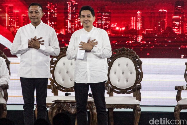 Tampil polos tanpa aksesori jadi pilihan paslon nomor urut 2, Dharma Pongrekun-Kun Wardana. Keduanya kompak memakai kemeja putih lengan panjang dengan kerah shanghai. Foto: Andhika Prasetia