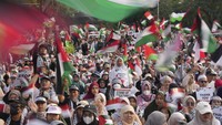 Para pengunjuk rasa mengibarkan bendera Palestina selama unjuk rasa yang mendukung warga Palestina di Gaza, di luar Kedutaan Besar AS di Jakarta, Minggu (6/10/2024). Massa menuntut agar Washington menghentikan pasokan senjata ke Israel.