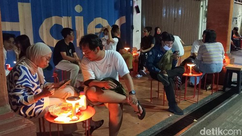 Sejumlah pembeli menikmati piza di Pizza Tjahaja yang berkonsep angkringan pinggir jalan di kawasan Jalan Gajah Mada, Denpasar, Bali, Sabtu (28/9/2024). (Foto: Aryo Mahendro/detikBali)