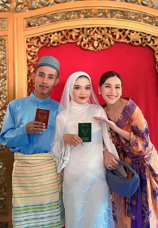 Berbeda dengan acara resepsi, di acara akad nikah asistennya itu Ayu tampil lebih formal mengenakan dress bercorak warna ungu dan peach. Riasan wajahnya juga lebih terlihat dibandingkan saat hadir di acara resepsi. Foto: Instagram/@ayutingting92