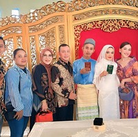 Sambil menenteng tas kecil yang senada dengan pakaiannya, penampilan Ayu terlihat anggun dengan sanggul klasik dan sepasang anting. Berpose di sebelah Sarah, Ayu tersenyum ke arah kamera. Foto: Instagram/@ayutingting92